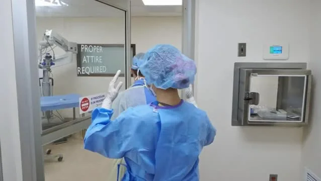 Technician in a sterile gown working in a cleanroom